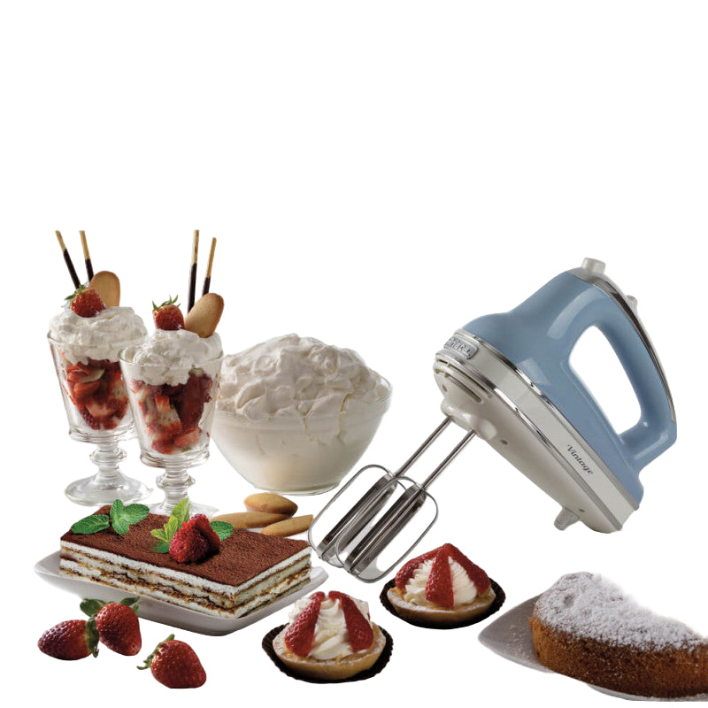 Hand mixer with desserts including tiramisu, strawberries, and whipped cream on a white background