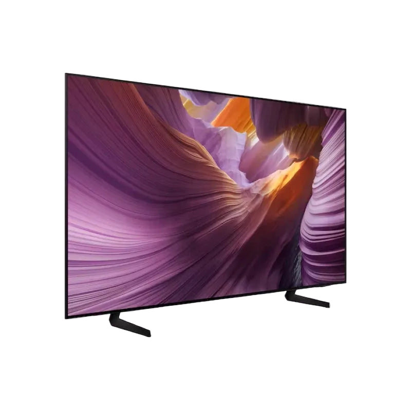 A modern flat-screen television with a thin black bezel and two angled black stand legs, shown at a three-quarter angle against a plain white background. The screen displays a colorful canyon landscape wallpaper.