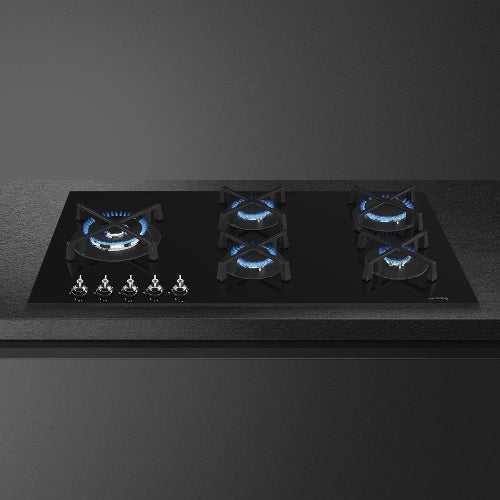 Black gas stove with blue flames on a dark background