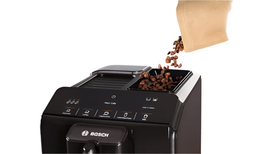 Bosch coffee machine with coffee beans being poured into it on a kitchen counter.